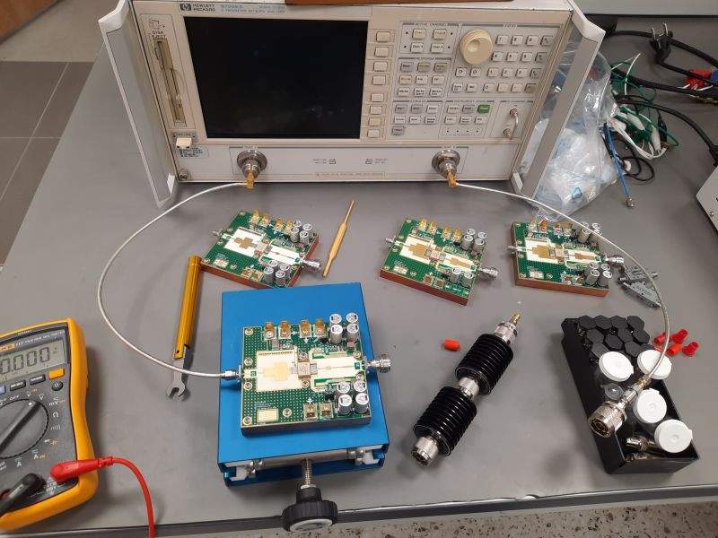 Laboratory bench showing E-REON S-band GaN power-amplifier application boards and RF test equipment
